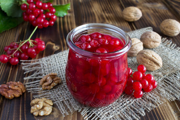 Viburnum jam and walnuts on the rustic background