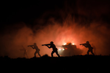 Obraz premium Military silhouettes of soldiers against the backdrop of dark foggy sky. Battle scene with explosion and burning clouds behind fighing soldiers. Toy decoration