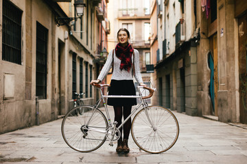 Chic woman with her vintage bicycle on the street.