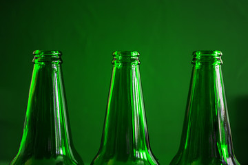 Conceptual beer background. Green beer bottles on a green background