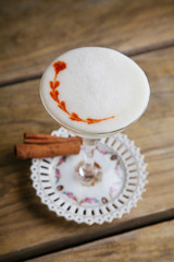 Foamed fall cocktail garnished with cinnamon sticks
