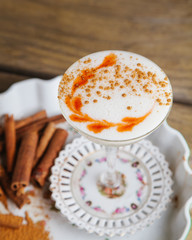 Foamed fall cocktail garnished with cinnamon sticks