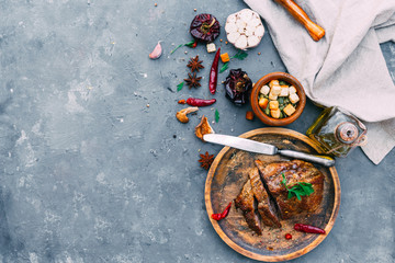 Grilled meat with spices. Vintage background. Flat lay