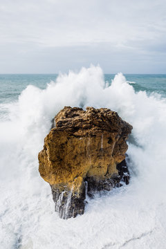 Violent wave splash knocking on the rocks