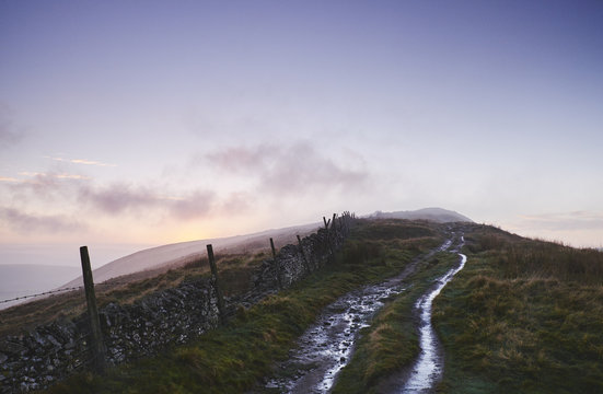 Mountain path and fence at sunset. Derbyshire, UK.