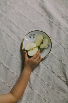 Hand holding a slice of an apple , vertical
