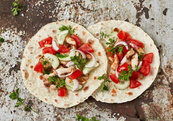 Grilled chicken and fresh vegetables salad tortilla. Healthy delicious breakfast or snack , top view