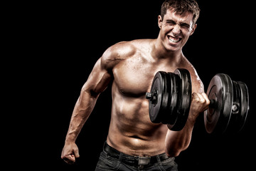 Fototapeta na wymiar Athletic shirtless young sports man - fitness model holds the dumbbell in gym. Copy space fore your text.
