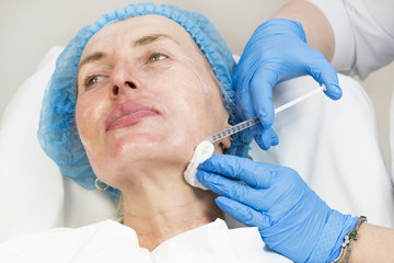 An adult woman undergoes cosmetic surgery in a beauty salon