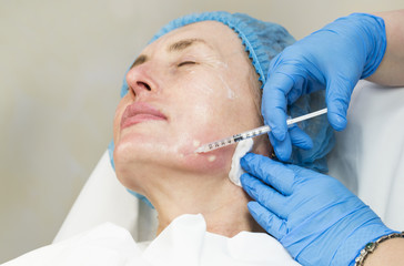 An adult woman undergoes cosmetic surgery in a beauty salon