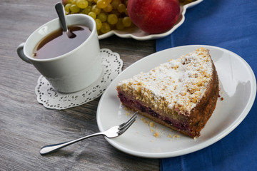 Vegan, raw berry cake on plate and cup of tea