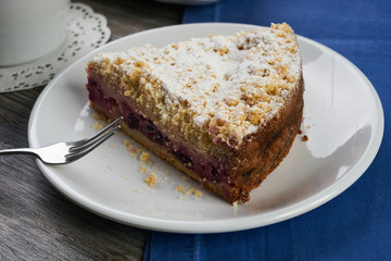 Vegan, raw berry cake on plate and cup of tea