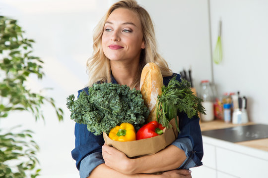 Beautiful Young Woman Grocery Shopping Bag With Vegetables At Home.