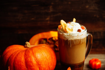 Pumpkin smoothie, spice latte. Boozy cocktail with whipped cream on top on a wooden background. Copy space Top view
