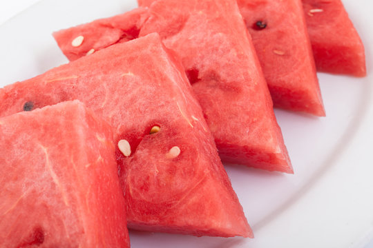 Triangle slices of fresh and juicy watermelon on white plate