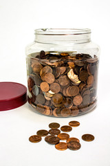 Penny coin jar with lid off and pennies spilling out