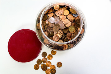 Penny jar with lid off and pennies spilling out