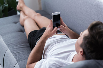 Young man is looking at screen of mobile phone