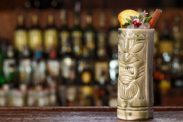exotic cocktail on the bar in tiki glass
