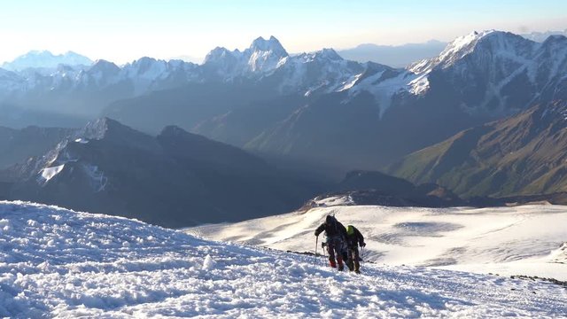 Group of Climbers in crampons coming up to the summit of Elbrus in Caucasus mountains. Snow peak.