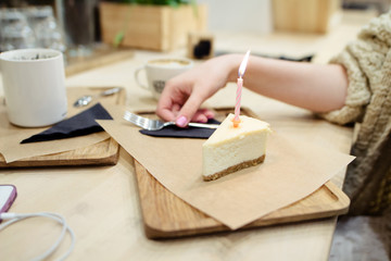cheesecake with a festive candle on a wooden tray