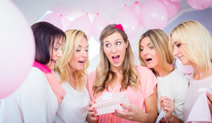 Obraz na płótnie Canvas Schwangere erhält Geschenke auf Baby Shower Party, sie feiert gemeinsam mit ihren Freundinnen