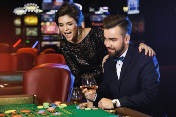 Beautiful and rich couple playing roulette in the casino