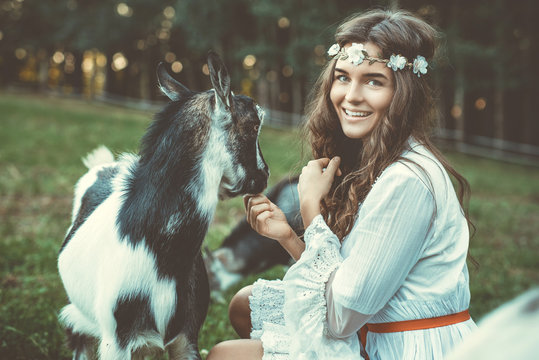 Young woman and funny friendly goat
