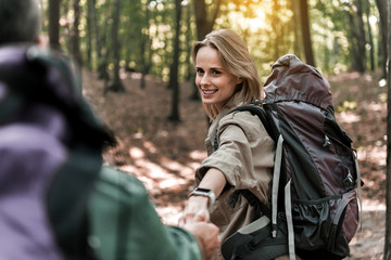 Joyful married couple going on pathway in the woods