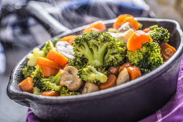 Vegan pan. Vegetarian food - broccoli carrot mushrooms salt pepper on butter