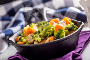 Vegan pan. Vegetarian food - broccoli carrot mushrooms salt pepper on butter