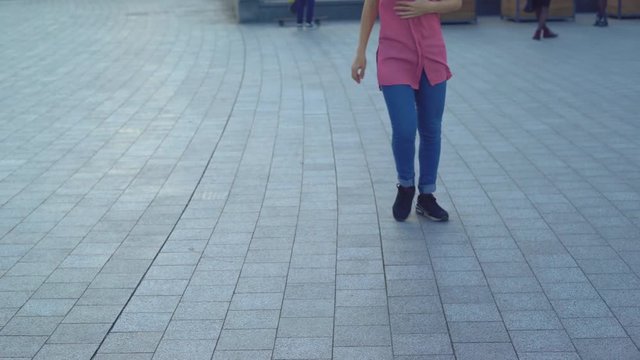young attractive woman on a bridge on the river bank. modern extreme dances in the style of hip-hop and classical ballet. the girl rhythmically moves to the music. The girl uses a handrail as a dance