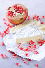 Obraz na płótnie Canvas Camembert cheese, sliced cheese, lots of cheese with pomegranate seeds on white background