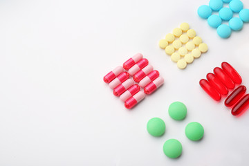 Composition with different colorful pills on white background