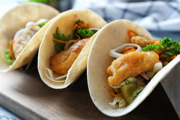 Stand with delicious fish tacos on table