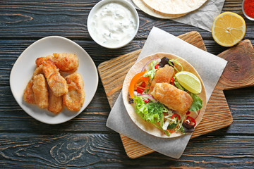Composition with delicious fish taco on wooden background