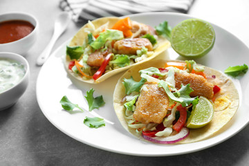 Plate with delicious fish tacos on table, closeup