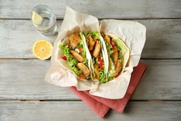 Delicious fish tacos on wooden table