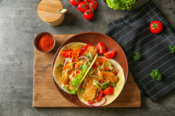 Plate with delicious fish tacos on table