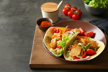 Plate with delicious fish tacos on table
