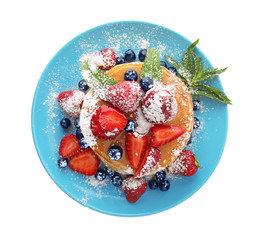 Plate with tasty pancakes and berries on white background