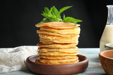 Plate with tasty pancakes on table