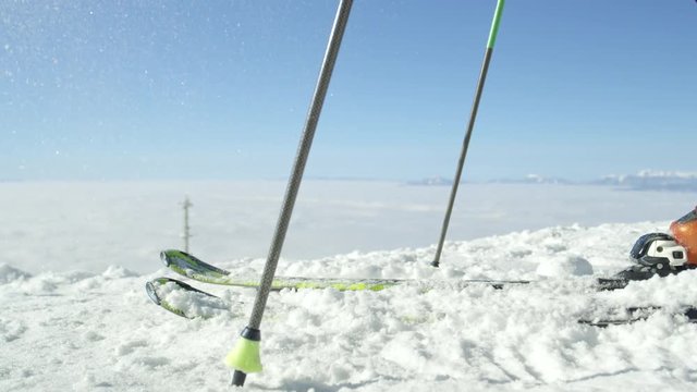 SLOW MOTION CLOSE UP: Skier on vacation preparing to drop on the track and start skiing on-piste at European ski resort in the Alps. Sunny cold winter day without any clouds above the fog, no people
