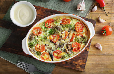 Baking dish with tasty broccoli casserole on wooden table