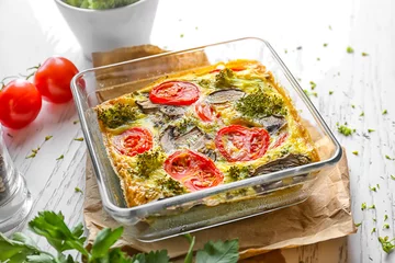 Poster Gerechten Baking dish with tasty broccoli casserole on white wooden table