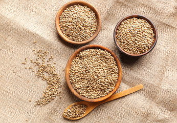 Bowls and spoon with hemp seeds on sackcloth