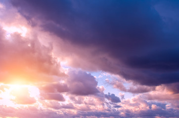 Storm clouds and rays of the sun through them at sunset.