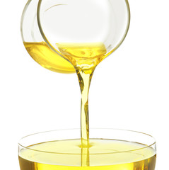 Pouring cooking oil from glass jug on white background, closeup