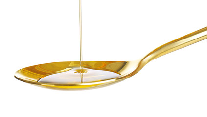 Pouring cooking oil into spoon on white background