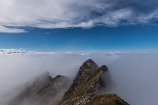 Der vorstehende Spitze im Nebel auf dem Hintergrund des blauen Himmels